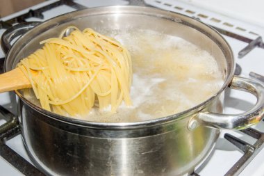 Bir gaz sobası üzerinde kaynar suda pişmiş spagetti.