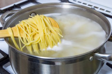 Bir gaz sobası üzerinde kaynar suda pişmiş spagetti.