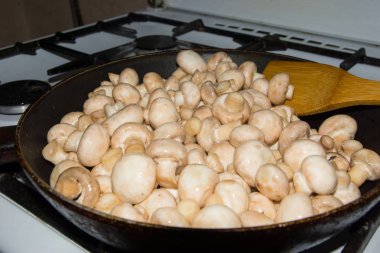 Küçük mantar bir bütün olarak bir tencerede kızartılır. Fried mantar soğan ile.