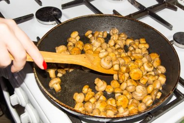 Küçük mantar bir bütün olarak bir tencerede kızartılır. Fried mantar soğan ile.