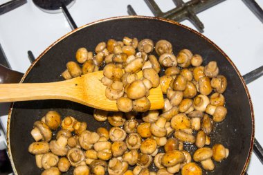 Küçük mantar bir bütün olarak bir tencerede kızartılır. Fried mantar soğan ile.