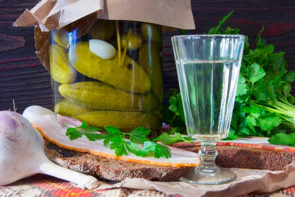 Traditional Ukrainian and Russian appetizer when dining. Food when drinking alcohol. Vodka and sandwiches with bacon, garlic and pickles. — Stock Image Traditional Ukrainian and Russian appetizer when dining. Food when drinking alcohol. Vodka and sandwiches with bacon, garlic and pickles. Stock Picture