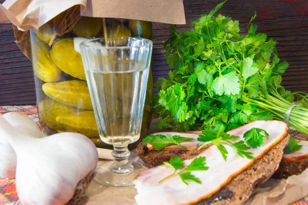 Traditional Ukrainian and Russian appetizer when dining. Food when drinking alcohol. Vodka and sandwiches with bacon, garlic and pickles. — Stock Image Traditional Ukrainian and Russian appetizer when dining. Food when drinking alcohol. Vodka and sandwiches with bacon, garlic and pickles. Stock Image