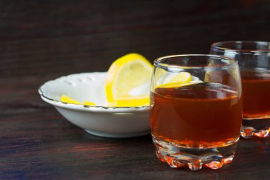 Bir kadeh alkol ve dilimlenmiş limon.