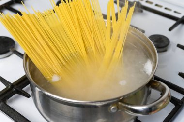 Spagetti bir gaz sobası üzerinde kaynar suda pişirilir. Geleneksel İtalyan yemekleri.