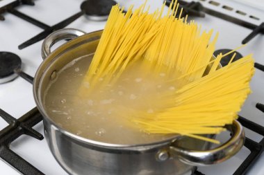 Spagetti bir gaz sobası üzerinde kaynar suda pişirilir. Geleneksel İtalyan yemekleri.