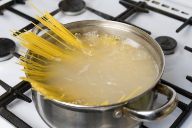 Spagetti bir gaz sobası üzerinde kaynar suda pişirilir. Geleneksel İtalyan yemekleri.