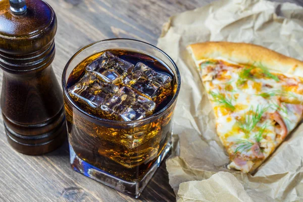 Delicious pizza with a glass of cold Cola with ice.