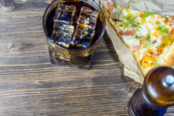Delicious pizza with a glass of cold Cola with ice.