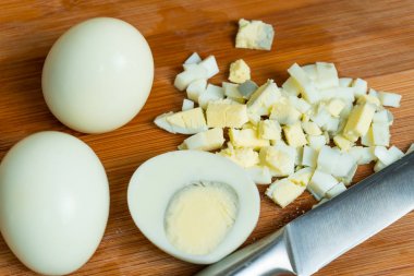 Farklı yemekler hazırlamak için haşlanmış yumurta kesti.