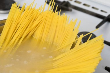 Spagetti bir gaz sobası üzerinde kaynar suda pişirilir. Geleneksel İtalyan yemekleri.