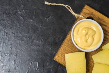 Siyah bir zemin üzerine peynir sos. Metniniz için yer.