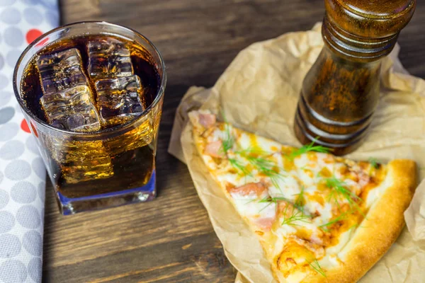 Delicious pizza with a glass of cold Cola with ice.