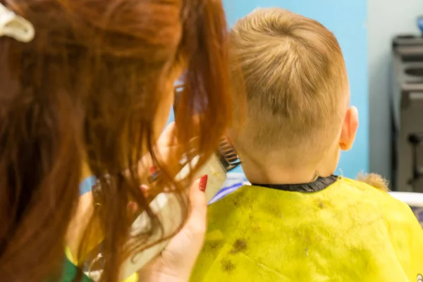 Frisören klipper barnet. Frisyr närbild. — Stockfoto