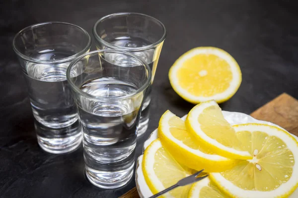 Un bicchiere di vodka. E la fetta di limone su un piatto. Posto per il testo . — Foto Stock