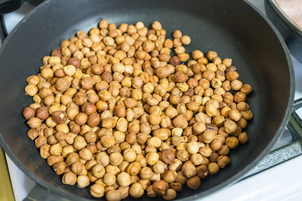 Fry hazelnuts in a frying pan. fresh nuts in the pan. — Stock Photo, Image