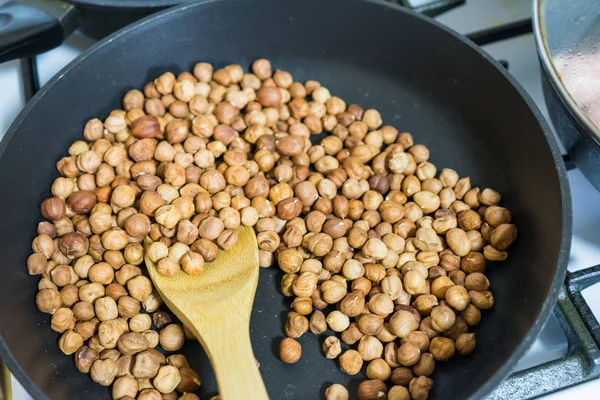 fry hazelnuts in a frying pan. fresh nuts in the pan.