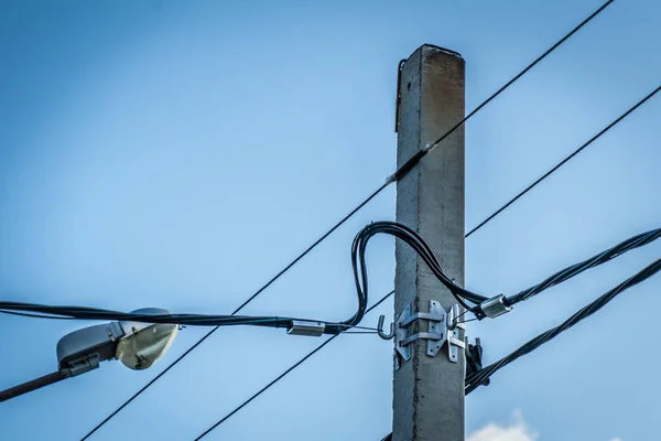 Elektrik direği. Gökyüzüne karşı elektrik kabloları olan bir direğin fotoğrafı..