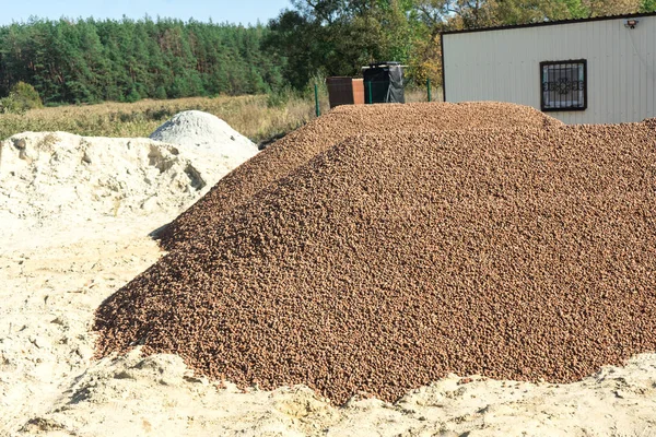 A lot of expanded clay in a pile on the construction site. — Stock Image A lot of expanded clay in a pile on the construction site. Stock Photo