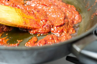 Kızartma tavasında domates sosu pişirmek. Tavada domates sosu pişirmek..
