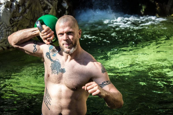 Posando con Kettlebell en frente de la cascada —  Fotos de Stock