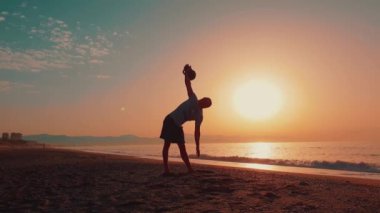 Bir Kettlebell Eğitmeninin Silueti Kettlebell Egzersizleri yaparken görülebilir