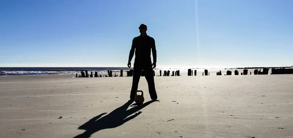 Güney Carolina Folly Sahili 'ndeki Kettlebell eğitmeninin silueti.