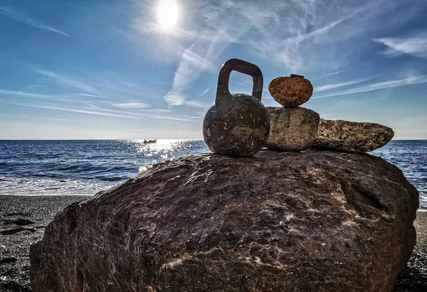 Sahilde arkada balıkçı teknesi olan bir kettlebell.