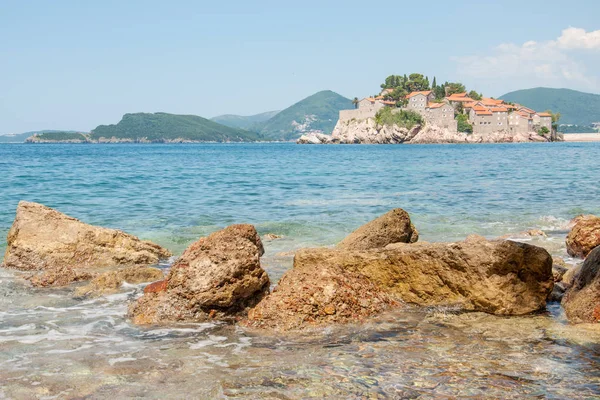 Una vista de la isla de Sveti Stefan y las montañas en un día de verano, Montenegro — Foto de Stock