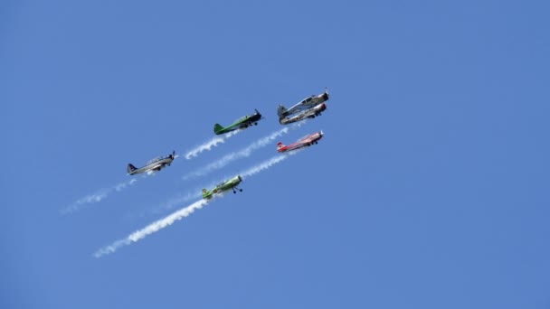 Colored propeller airplanes participate in jet races and smoke during air show. — 图库视频影像