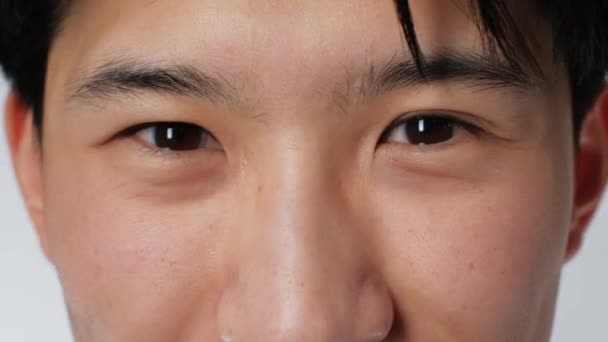 Senyum manis potret mata asia orang melihat kamera closeup latar belakang putih 4K — Stok Video