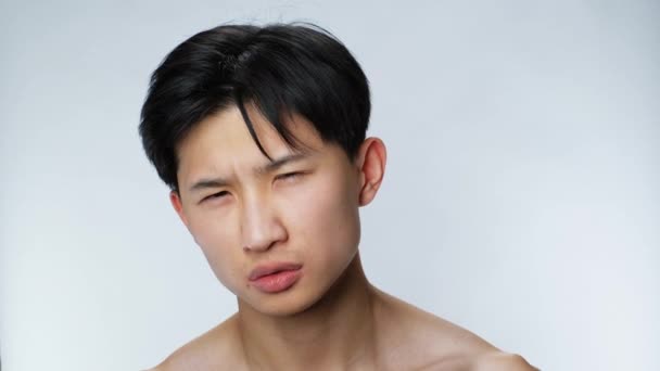 Open sight eyes handsome asian man looking at camera closeup white background 4K — Stock Video