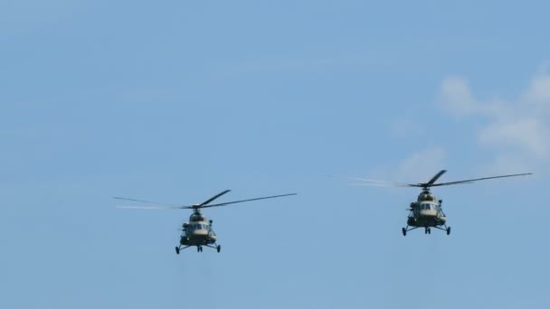 Two transport helicopters seem to hang in air, performing maneuvers, fly to war. — Stock Video
