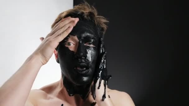 Charming person expressive use mud mask close up cosmetic white background 4K. — Stockvideo