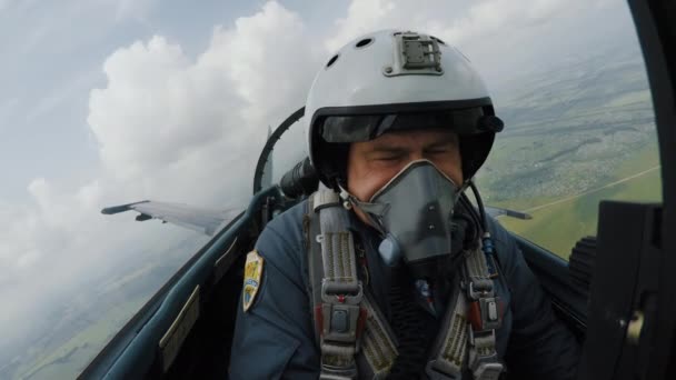 パイロットはコックピットに座って雲の中で戦争に飛び、トリックを実行する — ストック動画