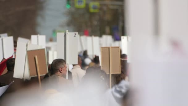 Crowd people walking down street Europe with banners defending their rights. — Stockvideo