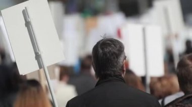 Afiş taşıyan bir mitingdeki kalabalık eylemcileri İngiltere 'ye doğru yürüyorlar..