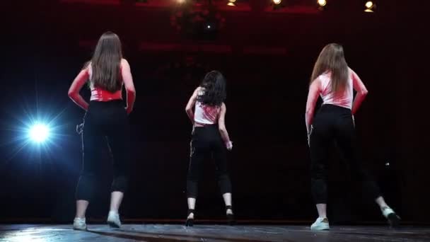 Trois femme danse hiphop sur scène vue arrière cheveux mouvement énergie dans la lumière rouge 4K — Video