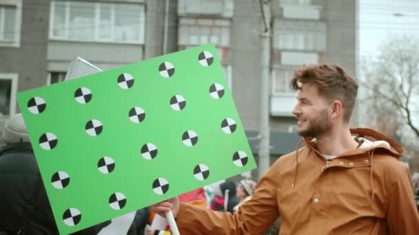 El hombre feliz sostiene la pancarta en la mano al aire libre. Punto de seguimiento para espacio de copia . — Vídeos de Stock