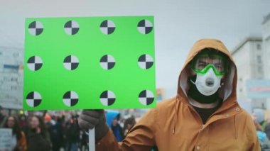 Gaz maskeli asi portresi. Öfkeli adam pankartı elinde tutuyor. Gaz maskesi direnci.