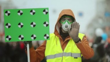 Gaz maskeli adam el hareketi. Çevre kirliliğini durdurun. İnsanlar kameraya bakıyor.