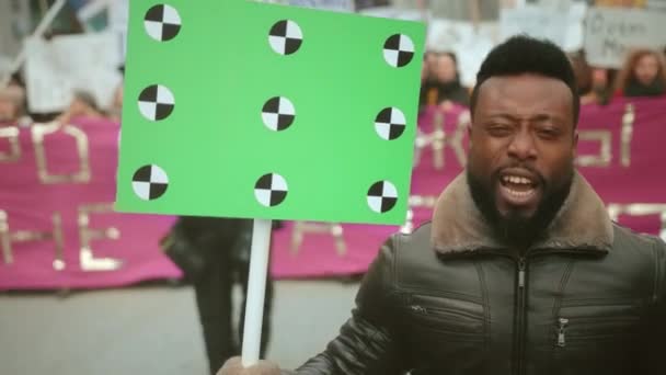 Zwarte Afro-Amerikaanse man schreeuwt een politiek protest staking gebeurtenis. Mensen uit het publiek. — Stockvideo