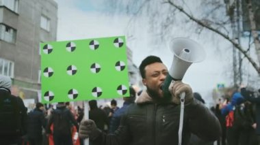 Afro-Amerikalı bir adam megafona bağırıyor. Afro siyah isyancı grevi protesto.