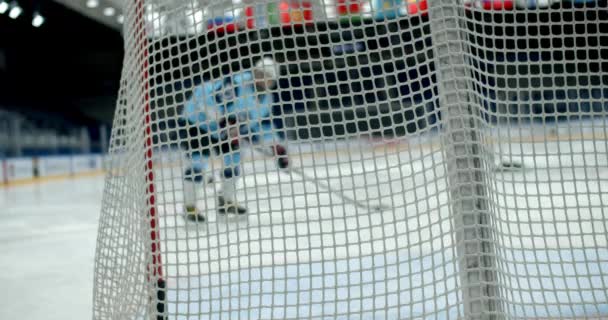 Frapper rondelle joueur de hockey à la porte de près les gens marquer le but lent mo sur la patinoire 4K — Video