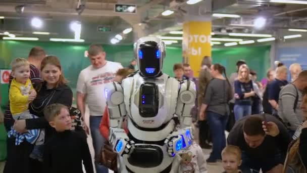 Mostrar capacidades tecnológicas en sala de exposiciones hombre androide caminar multitud gente — Vídeos de Stock