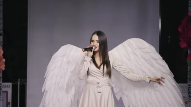 Attractive woman sing angel suit white wing close up sensual song model 4K. — Stock videók