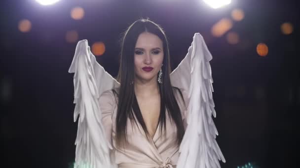 Attractive girl open eyes angel costume wing closeup look at camera slow motion. — Stok video