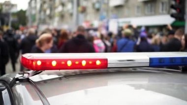 Flasher lights police car order close up on background crowd people strike.