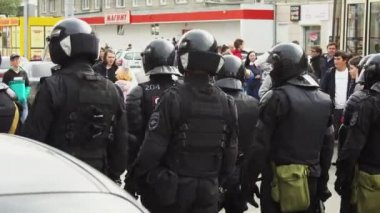 Kasklı bir grup silahlı polis 4K numaralı caddeyi kapatıyor. İsyancılar.