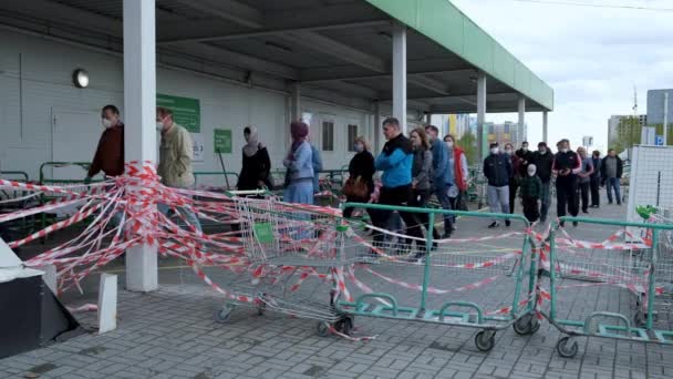 Kolejka wielu ludzi maskuje sklep z wirusami korony. Wózek kolejka czekać covid-19. — Wideo stockowe